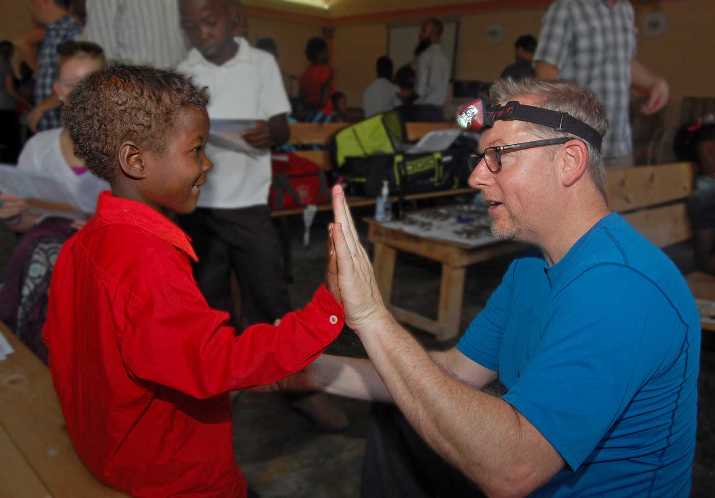 Photo of Dr. Boggan with a Haitian boy on a mission trip