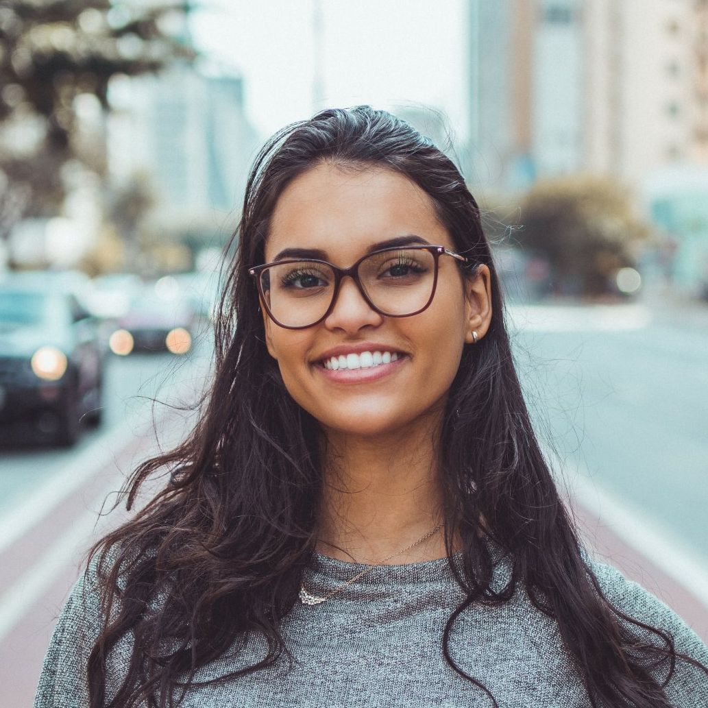 beautiful woman with glasses smiling in the street