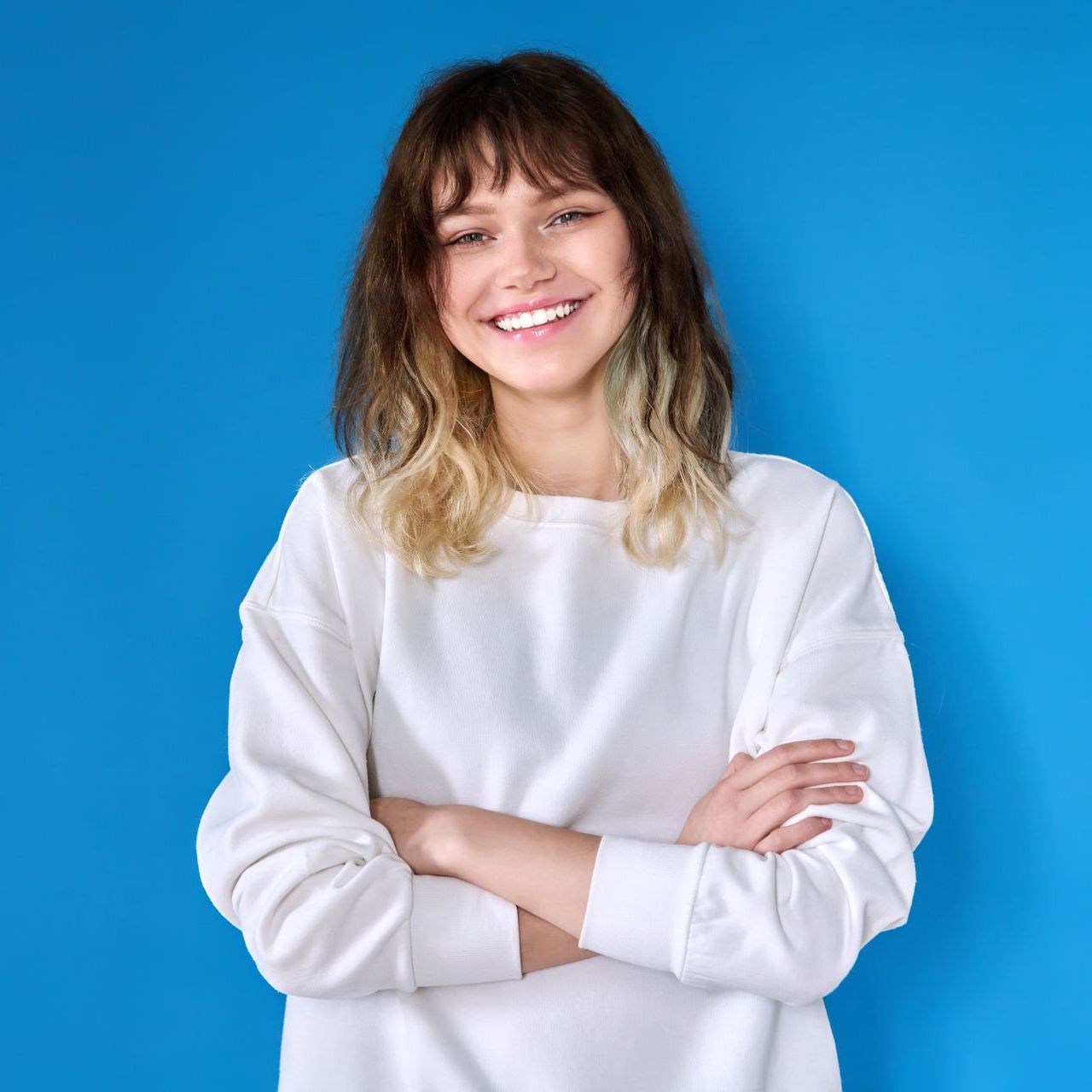 teenage girl smiling with blue background
