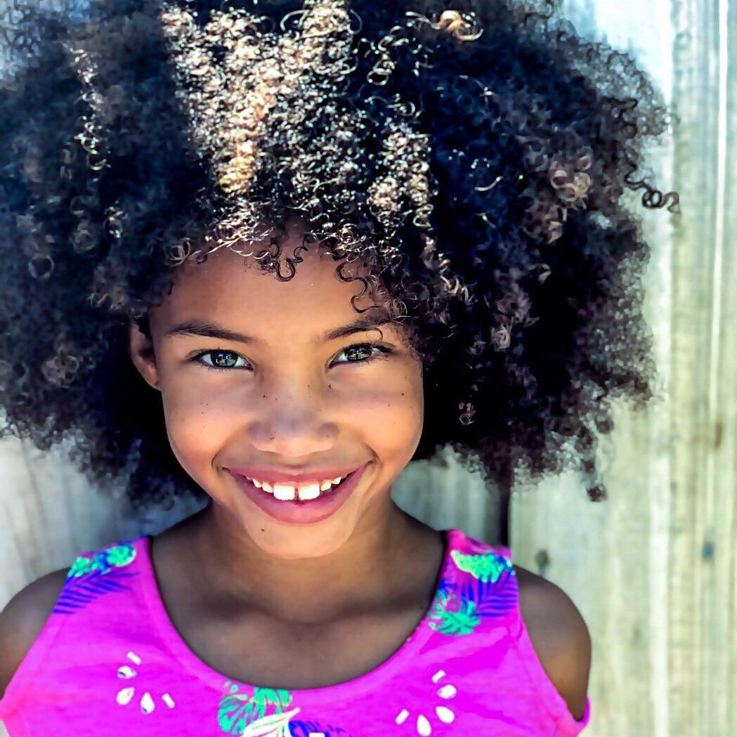 Young girl with beautiful curly hair, smiling