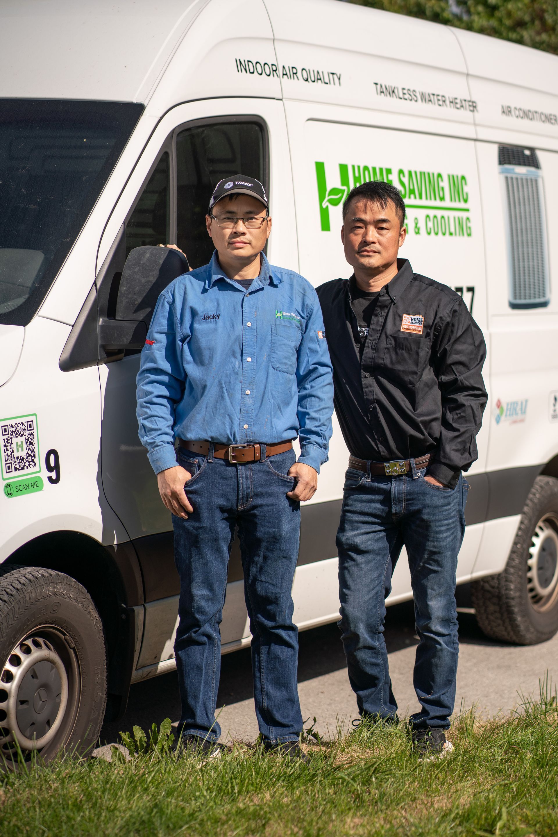 Two men stand by a white van. The van has the business logo 