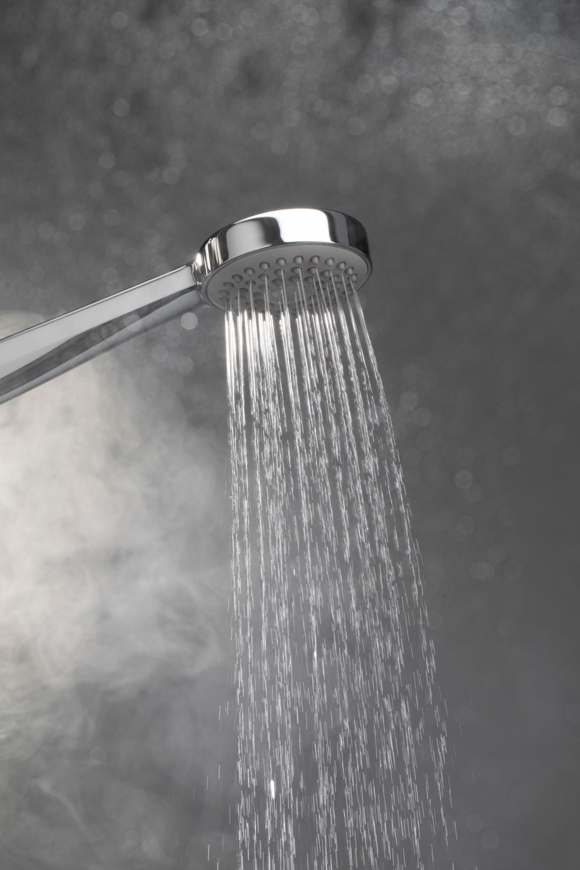 A close up of a shower head with water coming out of it.