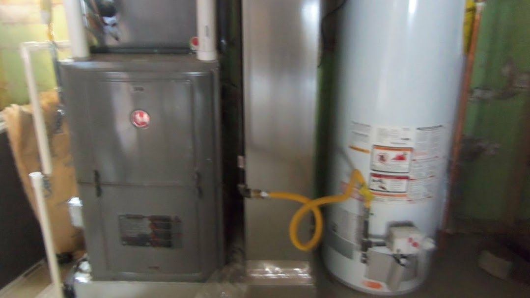 A water heater and a furnace are sitting next to each other in a room.