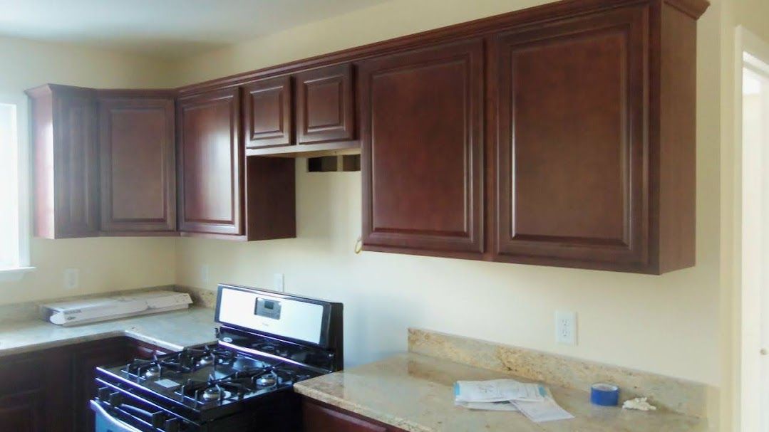 A kitchen with wooden cabinets and a stove.
