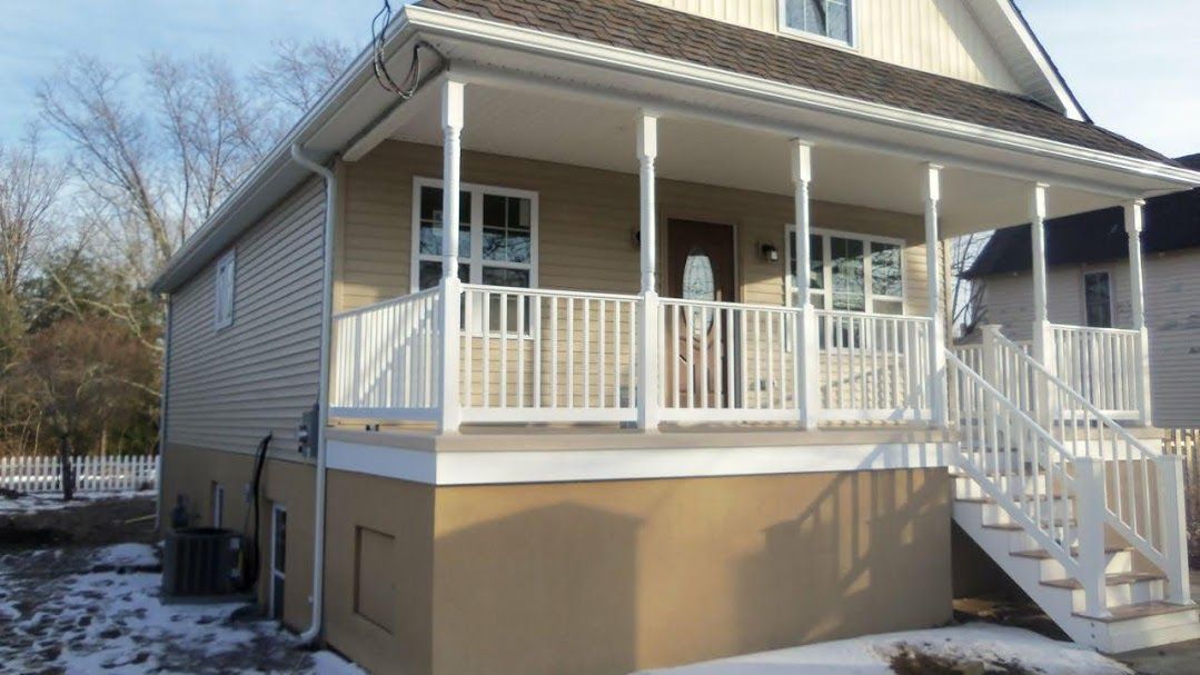 A house with a porch and stairs in the snow