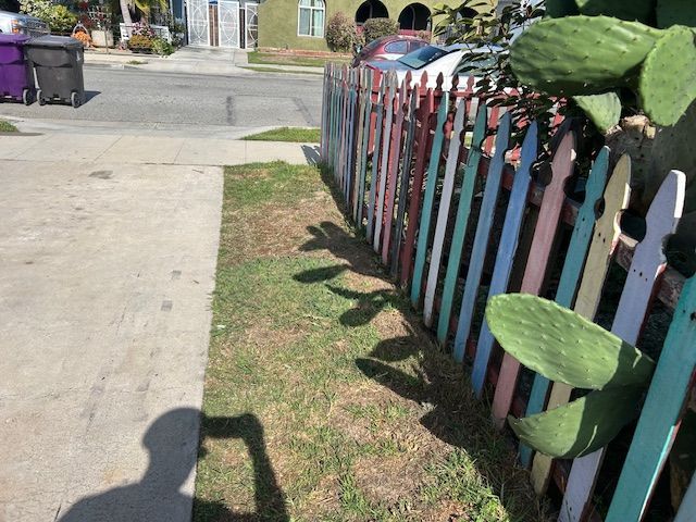 A tripod is sitting in front of a red fence