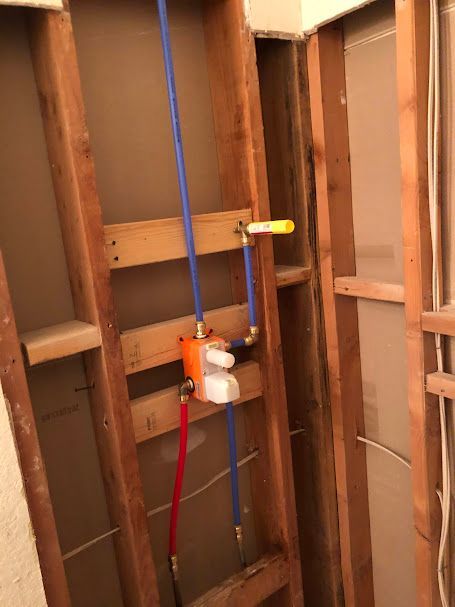 A bathroom with wooden walls and a faucet on the wall.