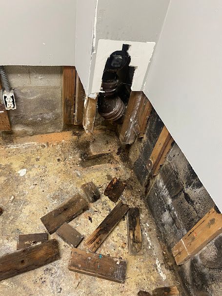 A bunch of wood is laying on the floor next to a wall.