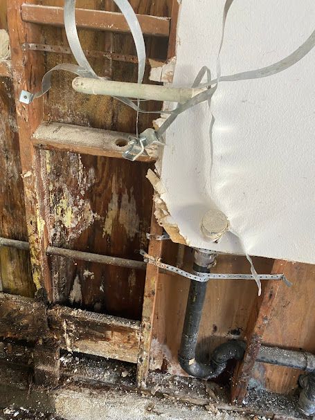 A wooden wall with a pipe coming out of it.