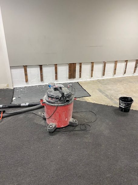 A red vacuum cleaner is sitting on the floor in a room.