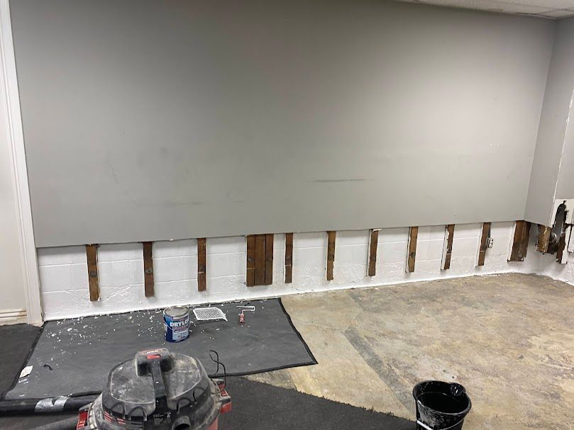 A room with a vacuum cleaner and a bucket on the floor.