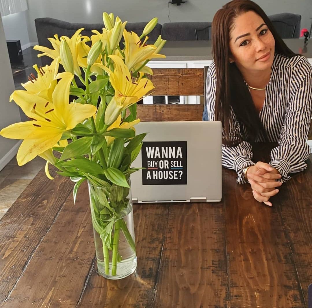 A living room with a couch , chairs , ottoman and a mirror