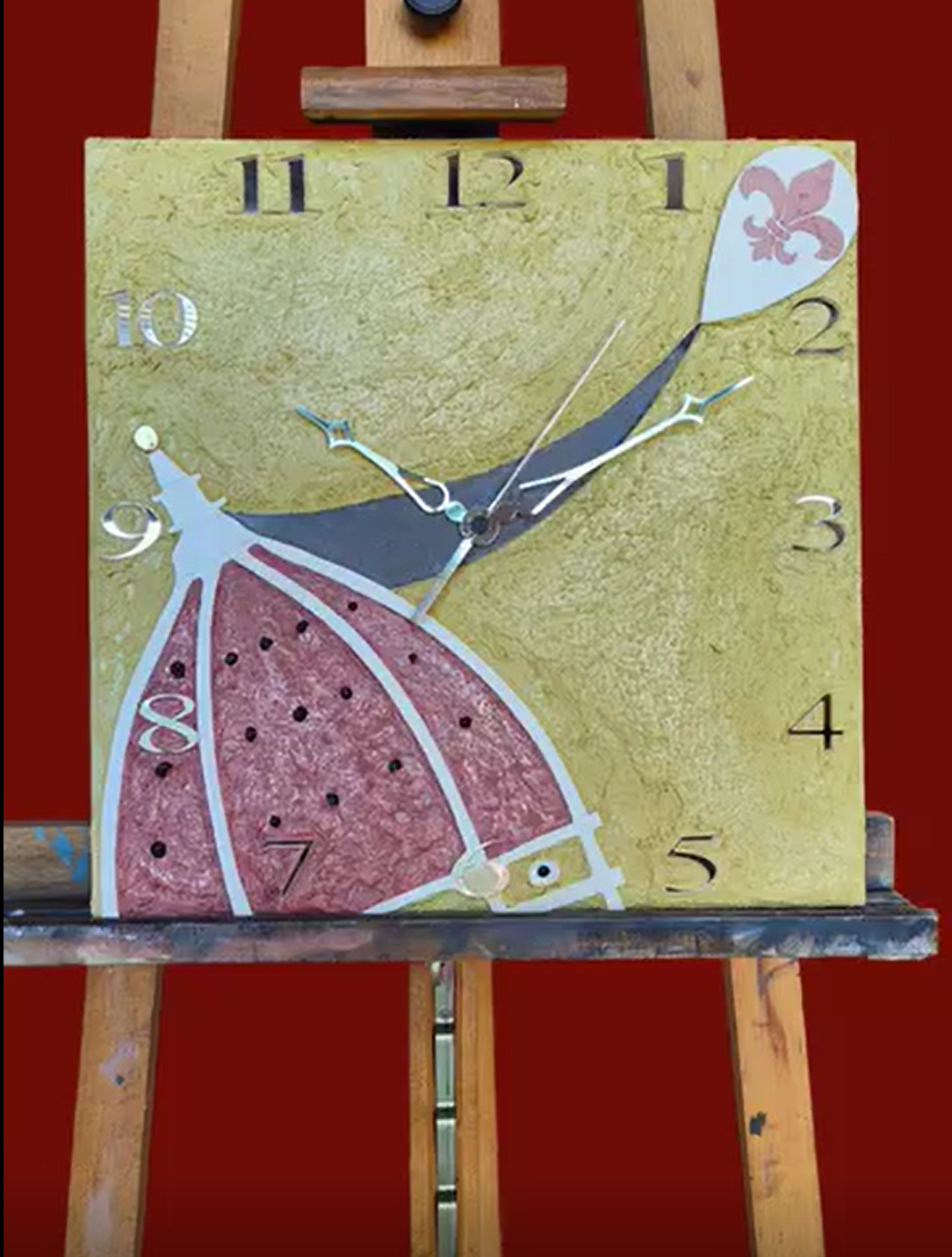 Un orologio su un cavalletto di legno con le lancette sui numeri 11 e 12