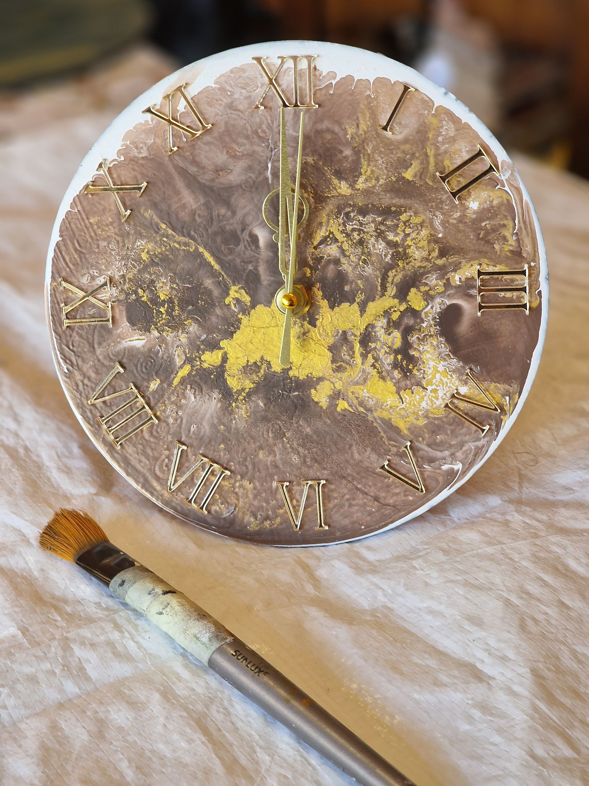 Un orologio con numeri romani e una spazzola accanto