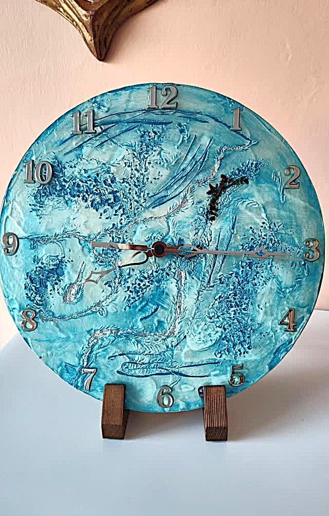 Un orologio blu e bianco è appoggiato su un supporto di legno su un tavolo.