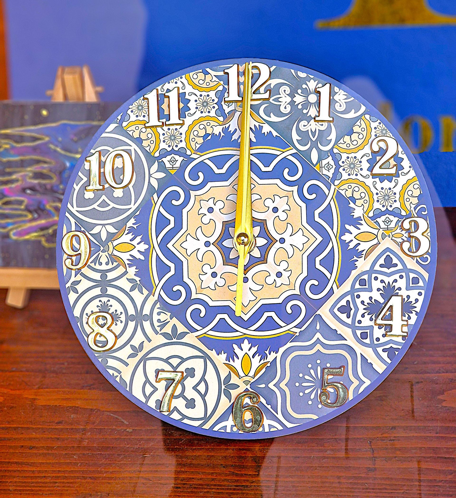 Un orologio blu e bianco con un motivo è appoggiato su un tavolo di legno