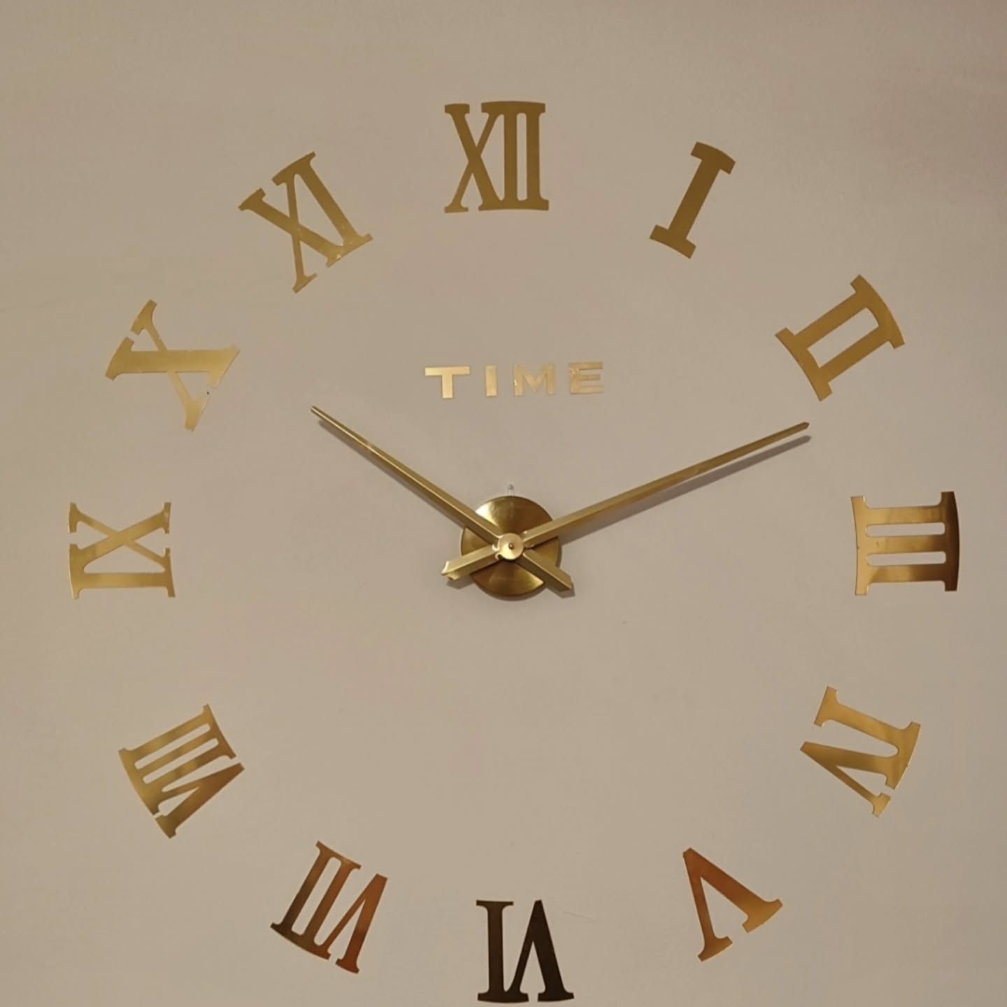 Un orologio con numeri romani su una parete bianca