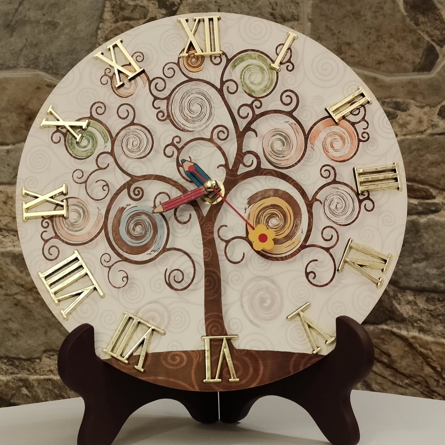Un orologio con numeri romani e un albero sopra
