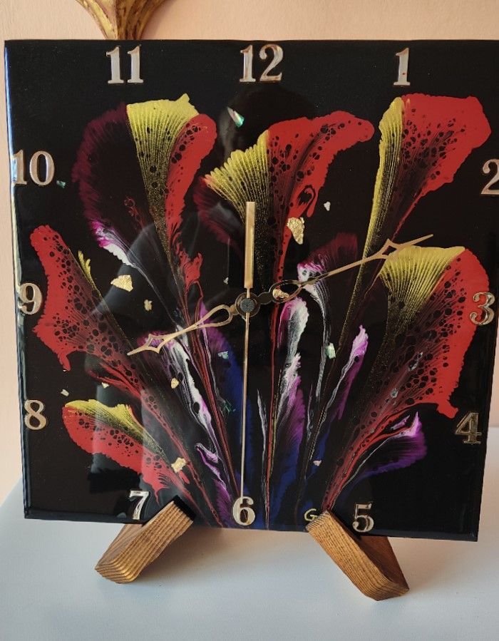 Un orologio quadrato con un'immagine di fiori sopra
