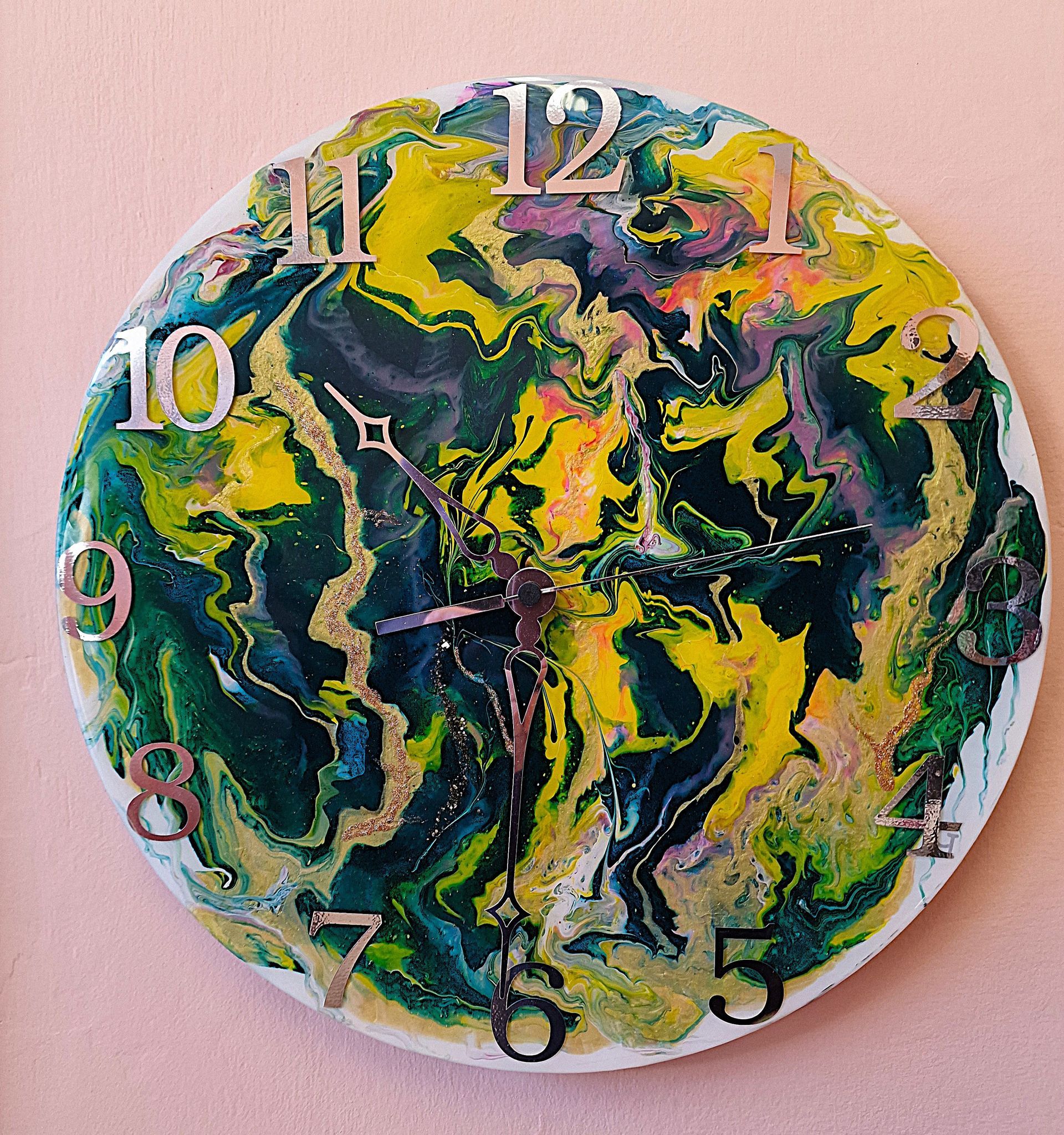 Un orologio colorato su una parete rosa segna le 10:10