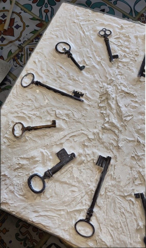 Un gruppo di chiavi è appoggiato su una superficie bianca.