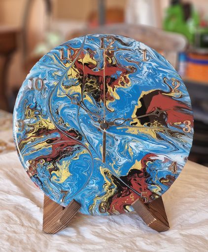 Un orologio su un supporto di legno con un disegno colorato