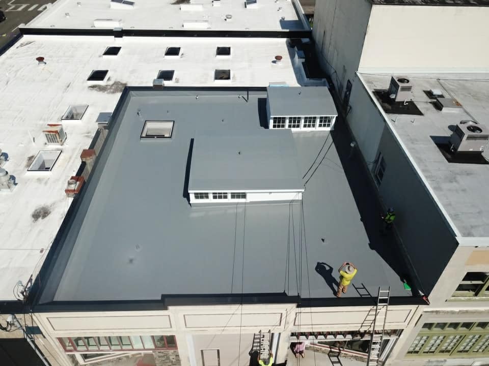 Man Taking Picture of Commercial Building Roof — Astoria, OR — Northwest Roofing & Construction LLC