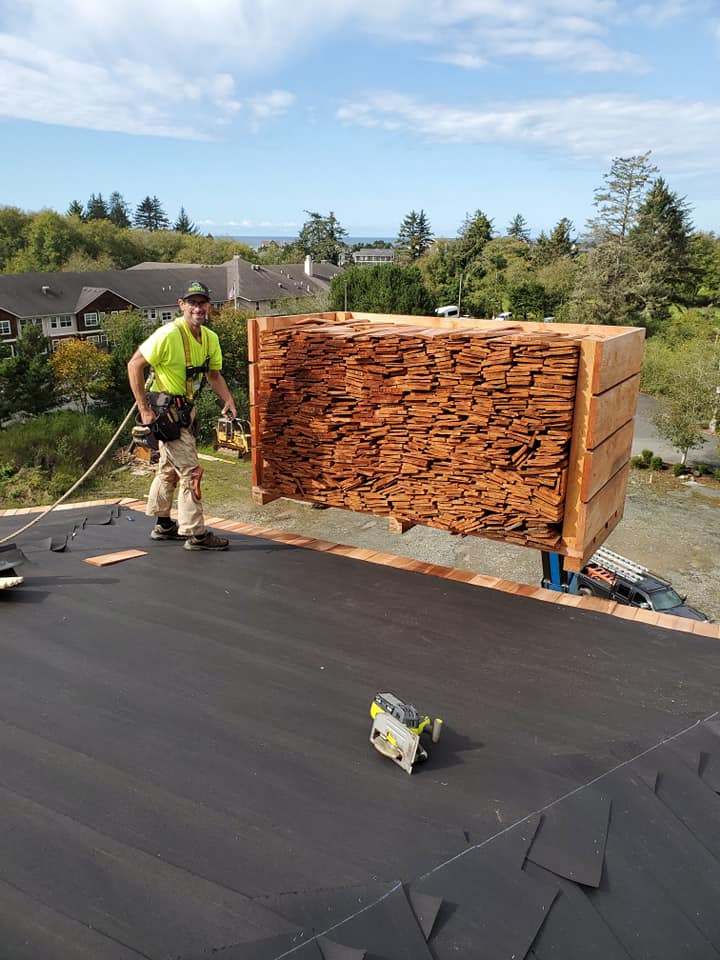 Man Standing in Front of Pile of Wood — Astoria, OR — Northwest Roofing & Construction LLC
