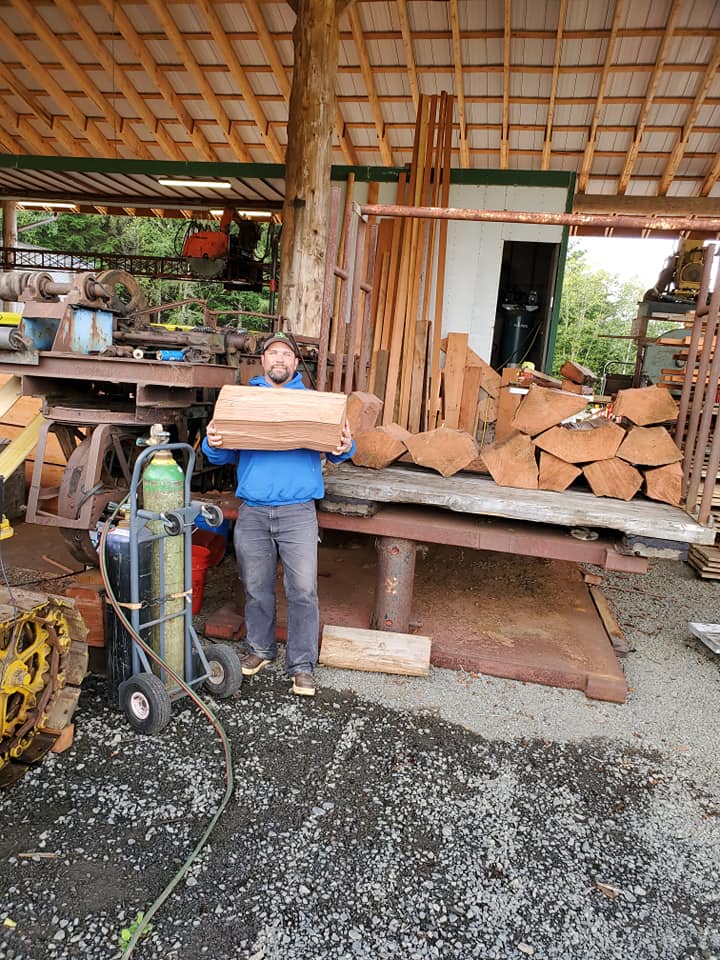 Man Holding A Chunk of Wood — Astoria, OR — Northwest Roofing & Construction LLC