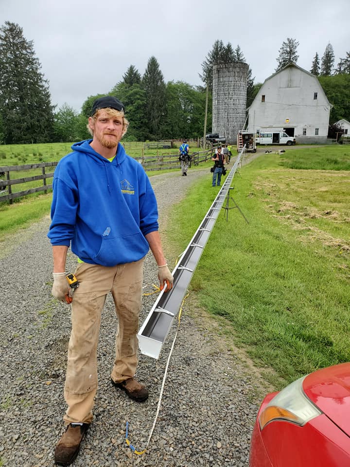 Man Standing Holding A Gutter — Astoria, OR — Northwest Roofing & Construction LLC