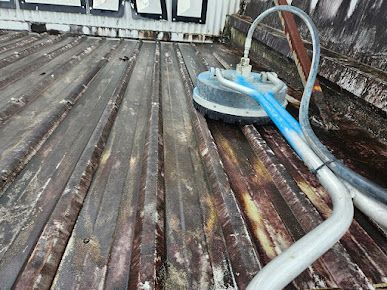 A Machine is Sitting on Top of a Wooden Deck — DJ's Pressure Cleaning In Carruchan, QLD