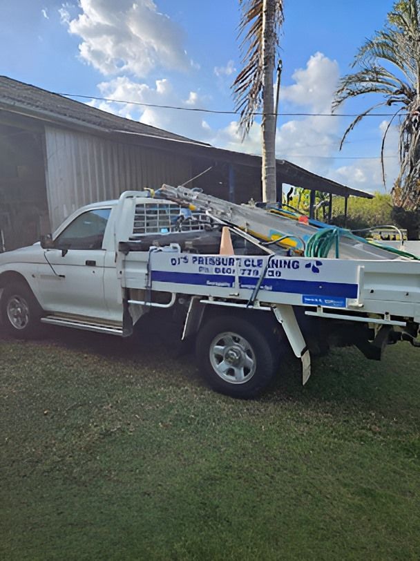 A White Truck With a Ladder on the Back is Parked in Front of a House — DJ's Pressure Cleaning In Carruchan, QLD