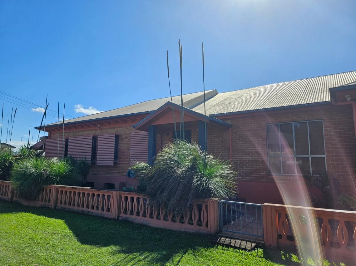 A Large Brick House With a Fence in Front of It — DJ's Pressure Cleaning In Innisfail, QLD