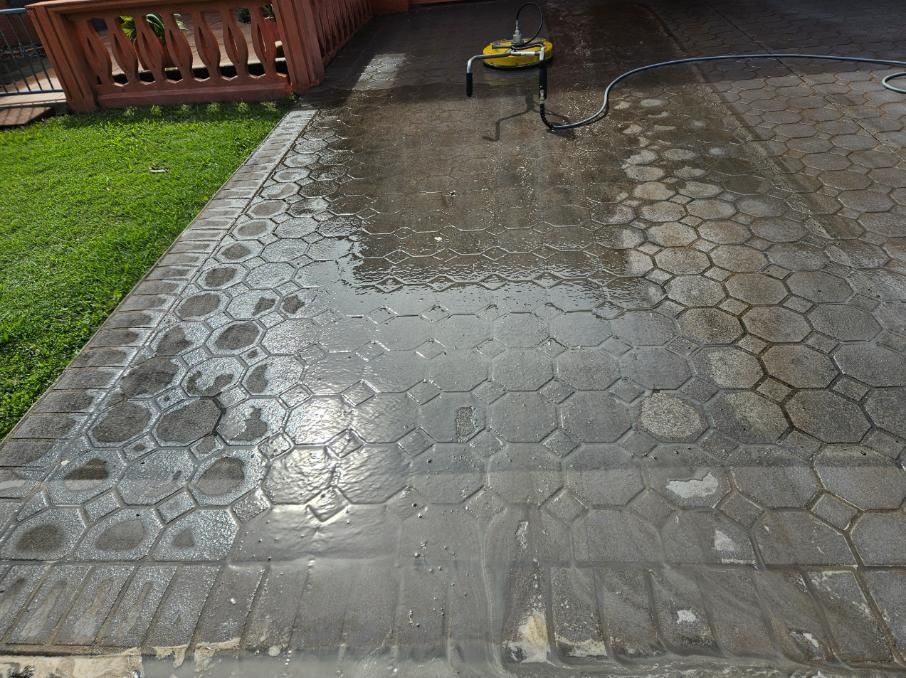 A Concrete Driveway is Being Cleaned With a High Pressure Washer — DJ's Pressure Cleaning In Innisfail, QLD