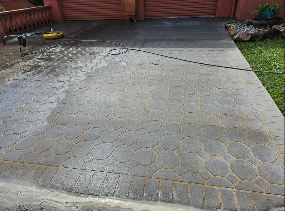A Brick Driveway Is Being Cleaned With A Pressure Washer — DJ's Pressure Cleaning In Ingham, QLD