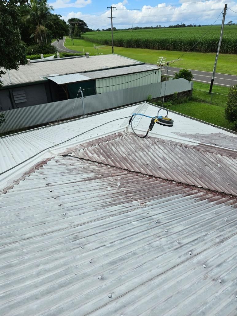 The Roof of a Building is Being Painted White — DJ's Pressure Cleaning In Carruchan, QLD