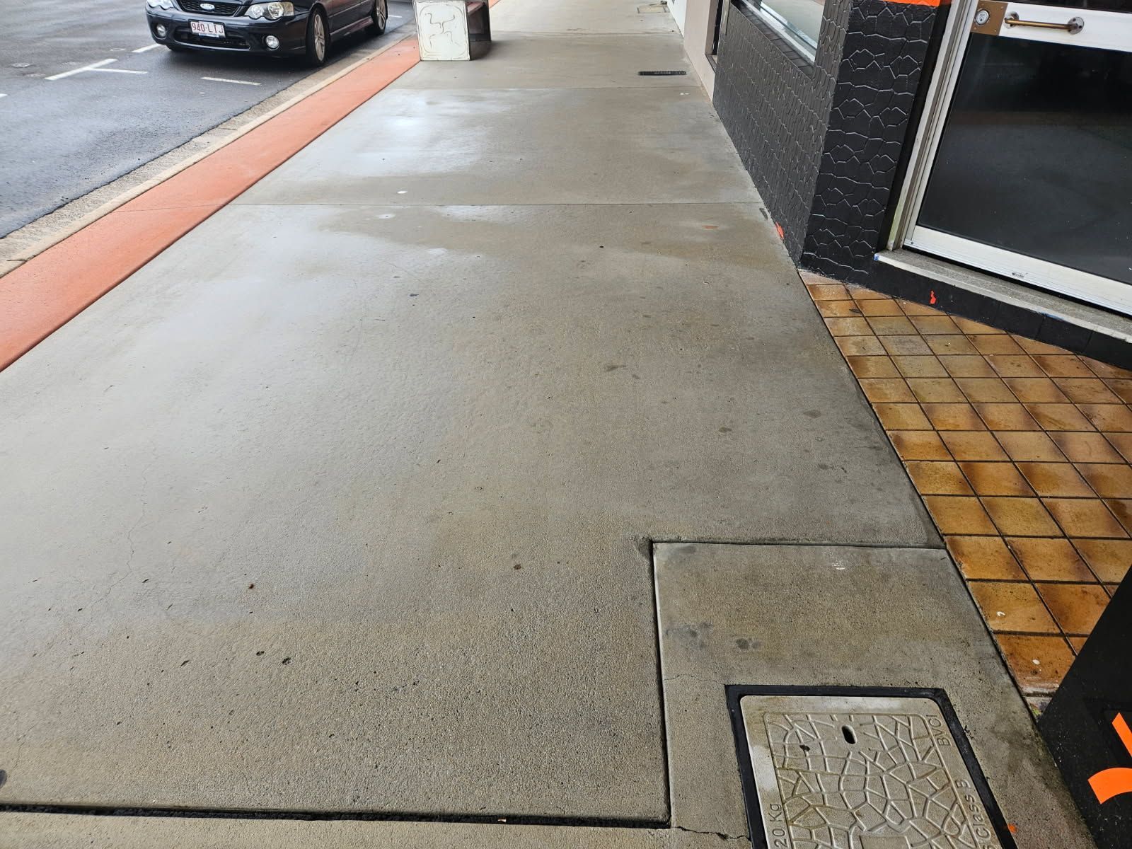 A Car is Parked on the Side of the Road Next to a Sidewalk — DJ's Pressure Cleaning In Carruchan, QLD
