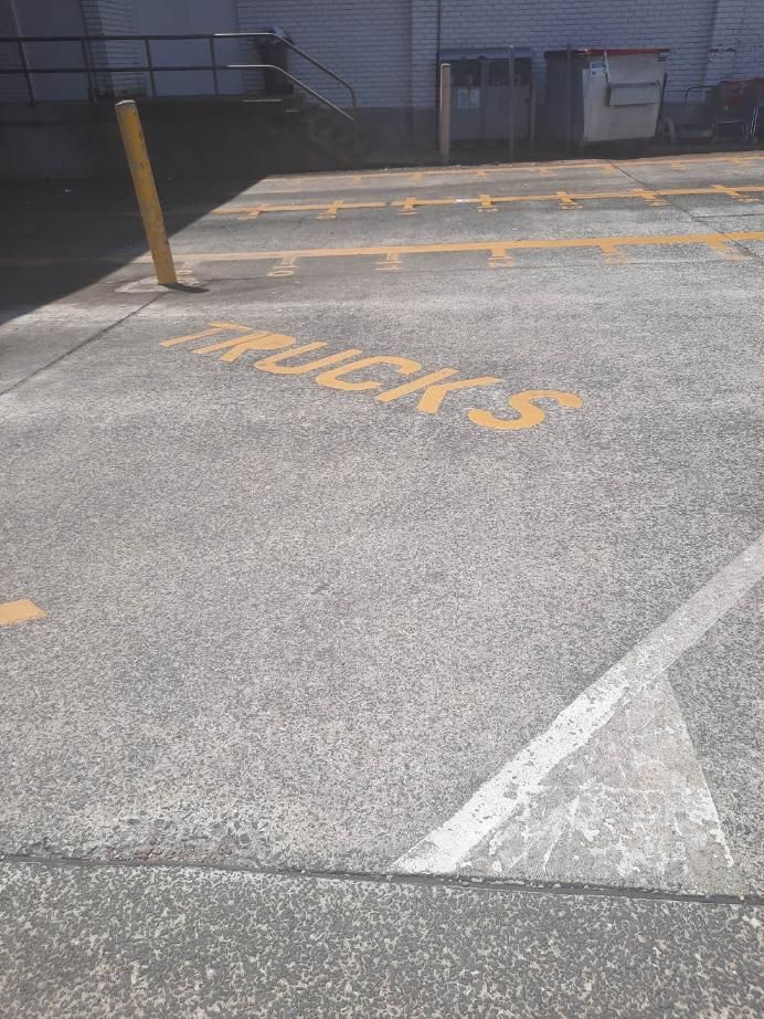 A Parking Lot With the Word Trucks Painted on the Ground — DJ's Pressure Cleaning In Carruchan, QLD