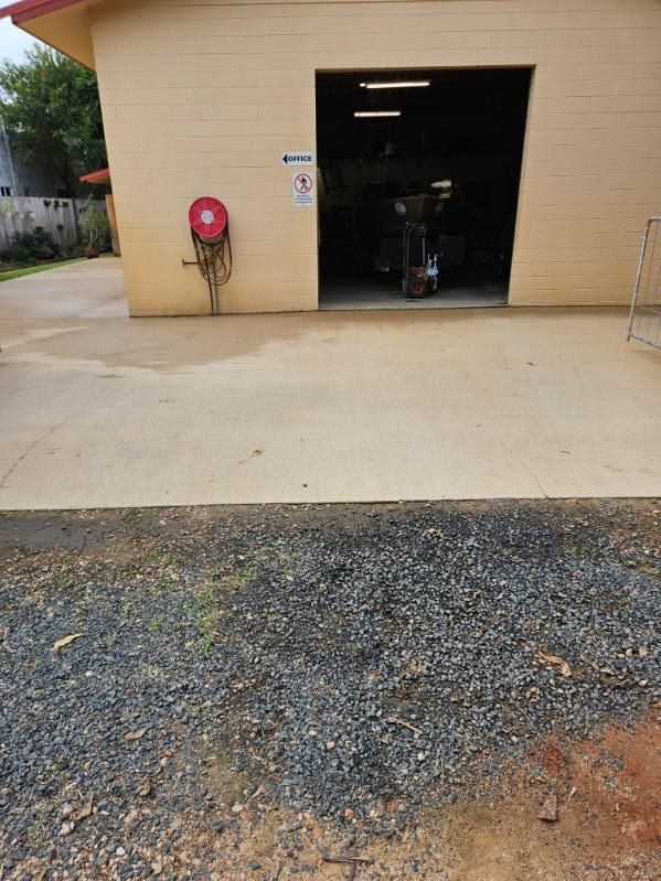 A Garage With a Fire Hose Hanging on the Side of It — DJ's Pressure Cleaning In Carruchan, QLD