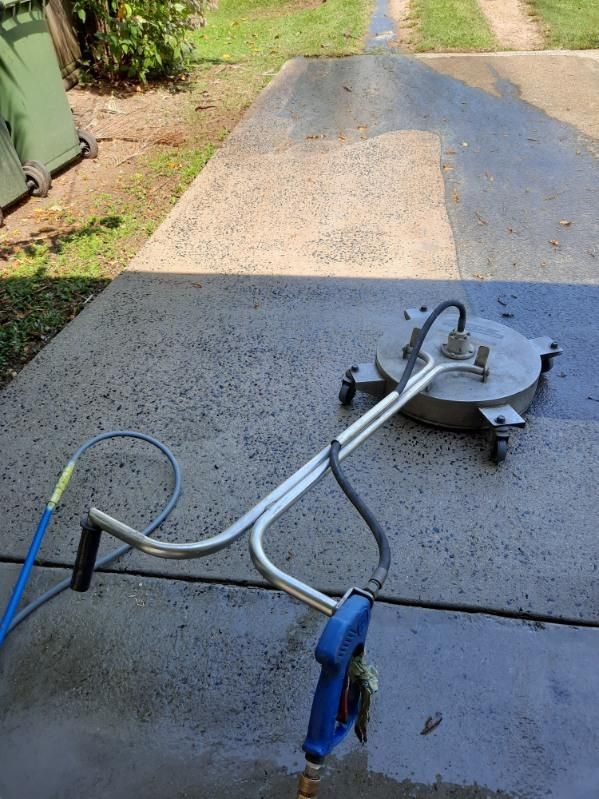 A Pressure Washer is Sitting on Top of a Concrete Driveway — DJ's Pressure Cleaning In Tully, QLD