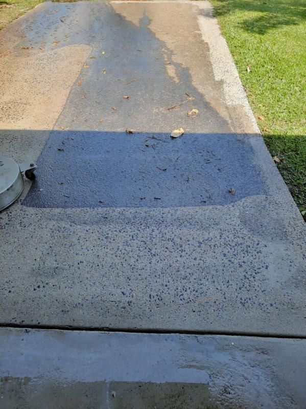 A Concrete Driveway With a Shadow of a Person on It — DJ's Pressure Cleaning In Tully, QLD