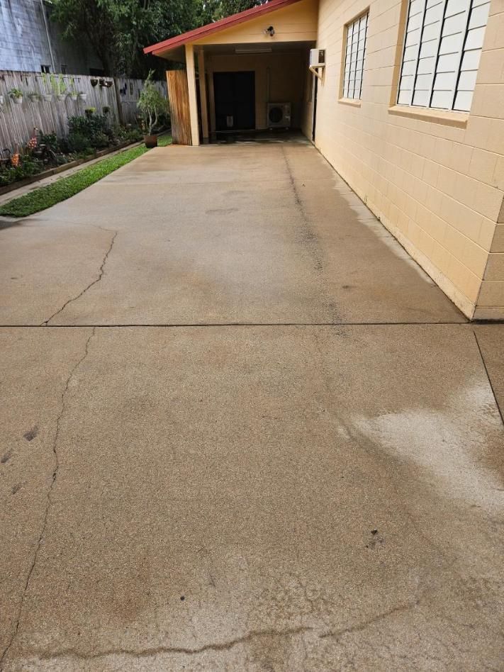 A Concrete Driveway Leading to a House With a Garage — DJ's Pressure Cleaning In Carruchan, QLD