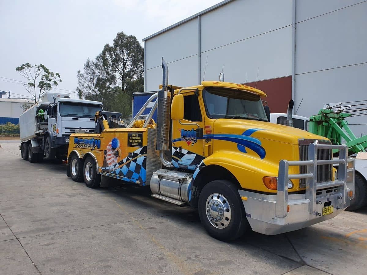 A Yellow Tow Truck Is Parked In Front Of A Building  — Newcastle Truck Repairs in Beresfield, NSW