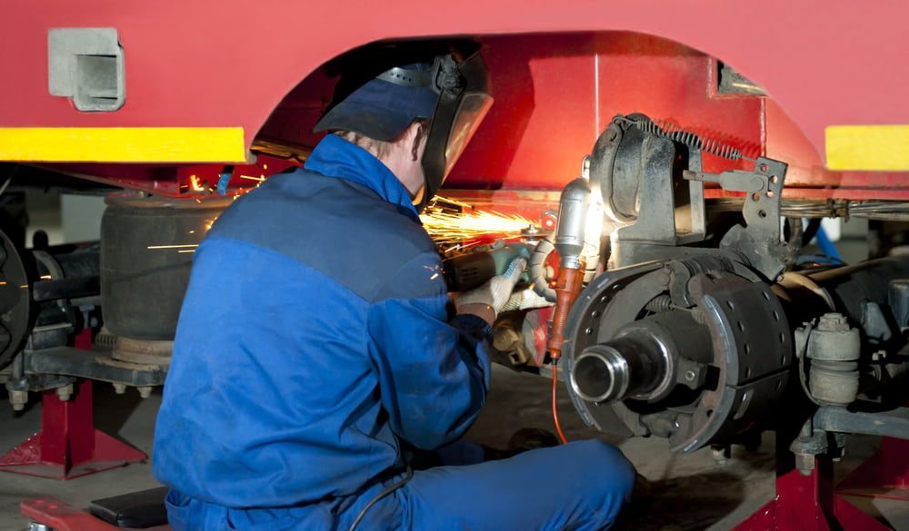 A Man Wearing A Welding Mask Is Working On A Vehicle  — Newcastle Truck Repairs in Beresfield, NSW