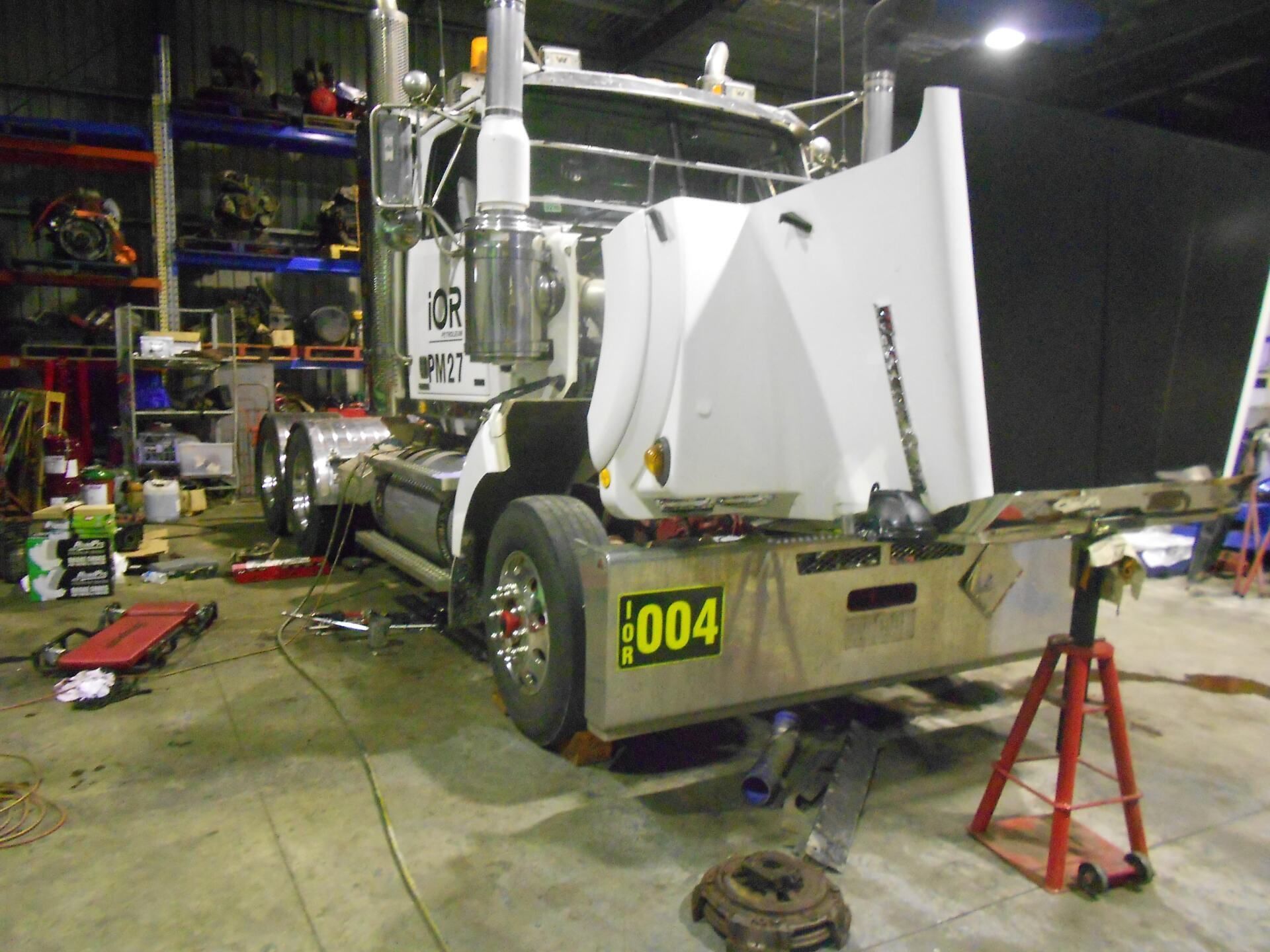 A Man Is Working On The Back Of A Semi Truck  — Newcastle Truck Repairs in Beresfield, NSW