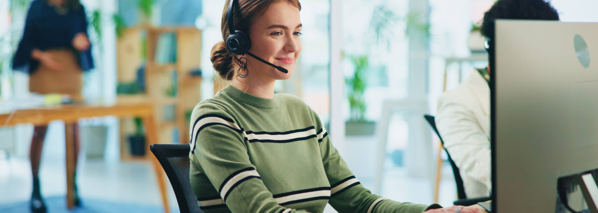 Picture of a person wearing a headset answering customer service calls. 