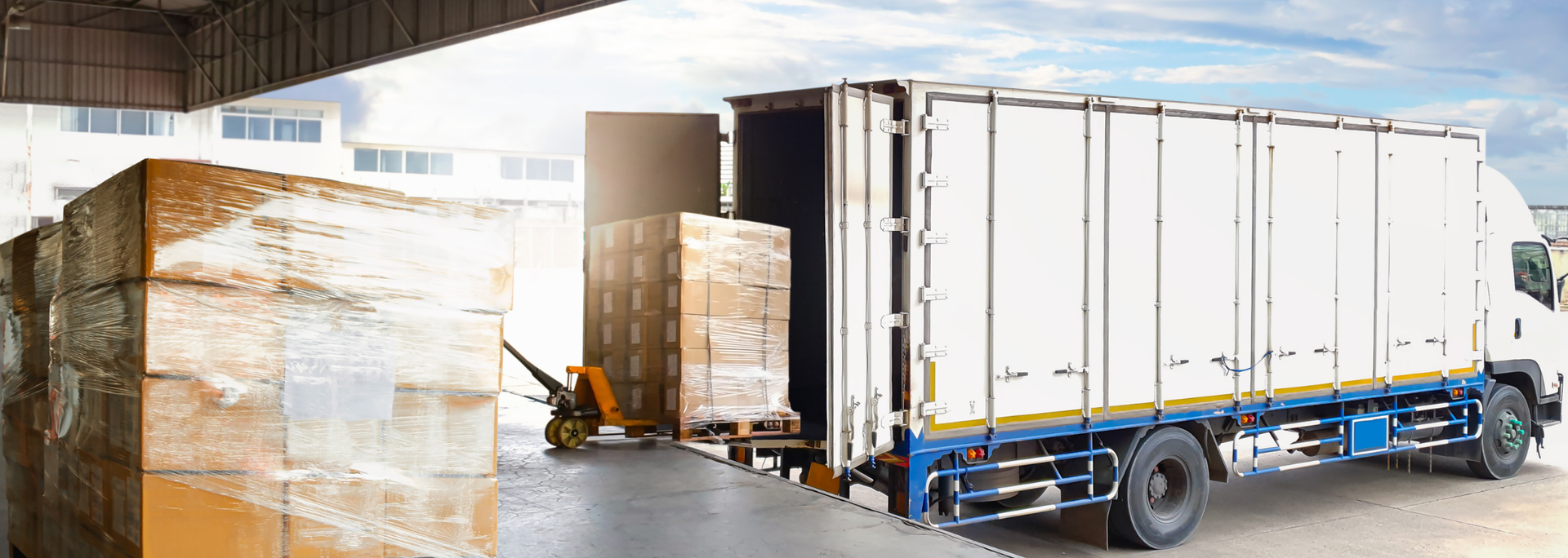 Picture of a lorry unloading goods at a warehouse. 