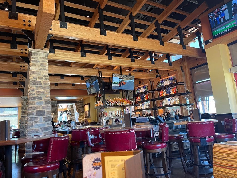 The inside of a restaurant with tables and chairs and a bar.