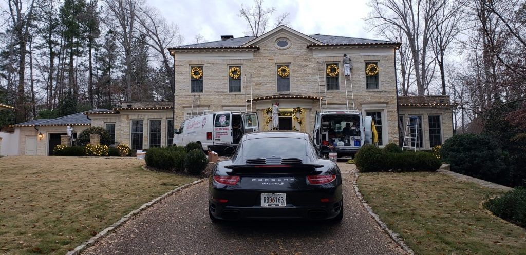 A car is parked in front of a large house.
