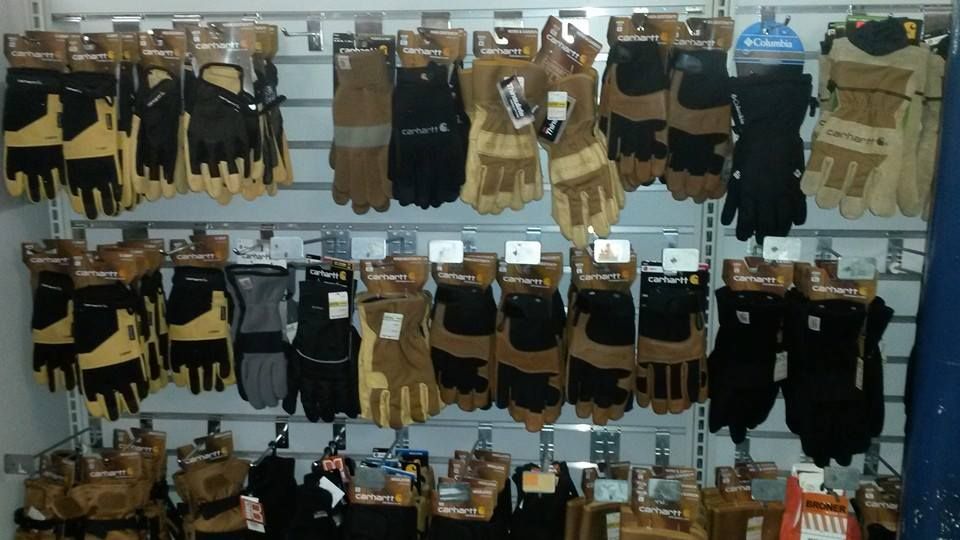 A bunch of gloves are hanging on a wall